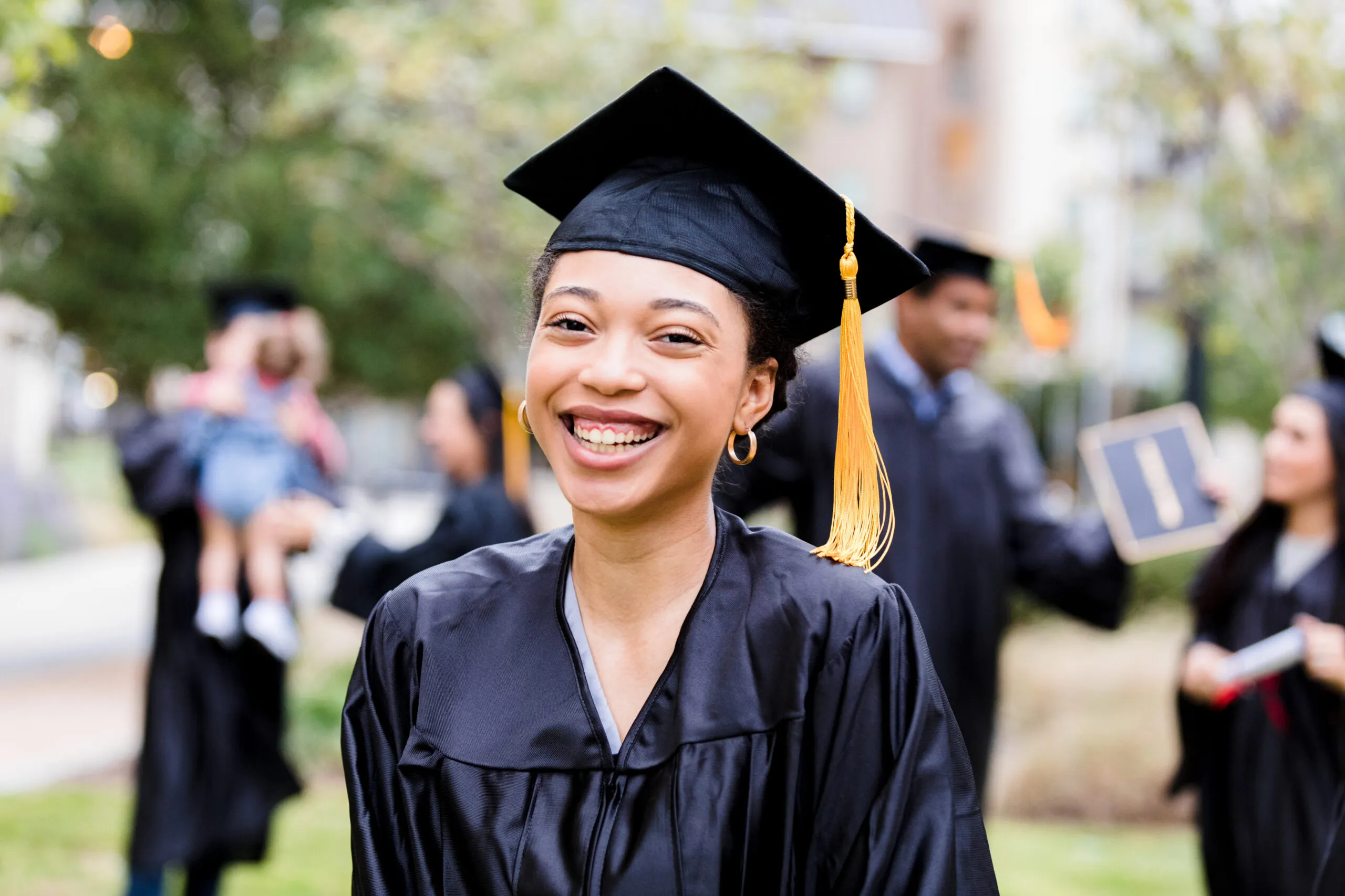 After graduation ceremony, woman smiles for photo